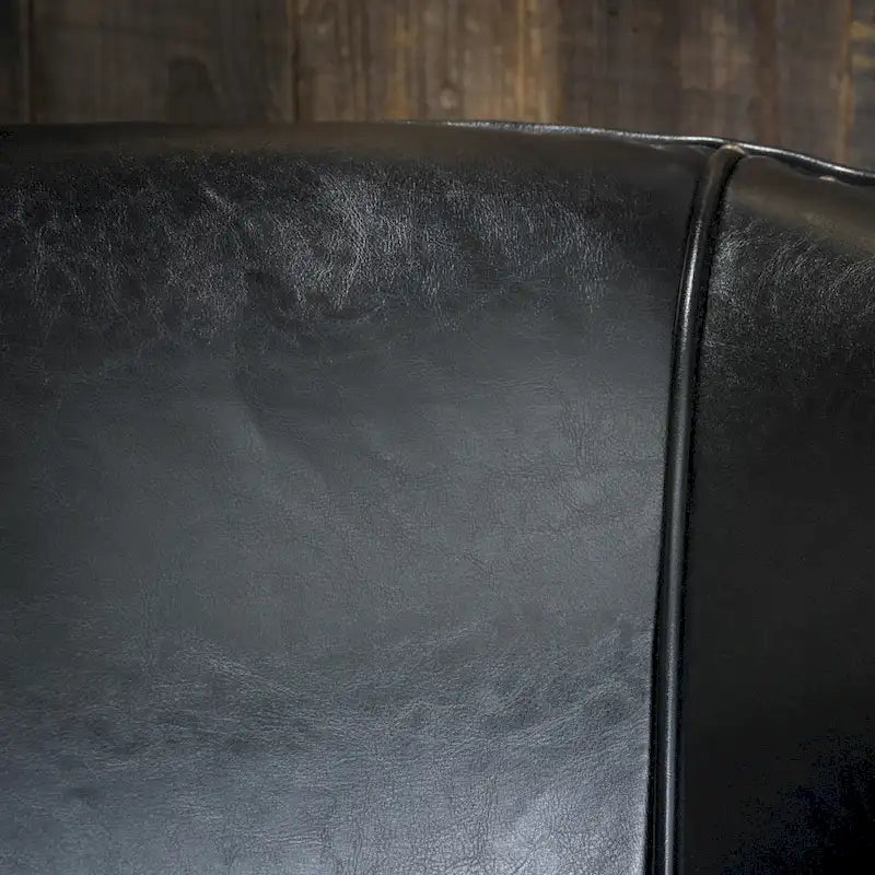 Fauteuil club noir en cuir reconstitué avec bordure de clous argentés